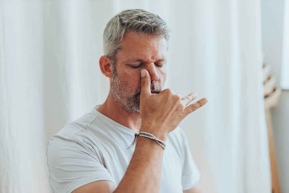 Man holding sinus area on his nose