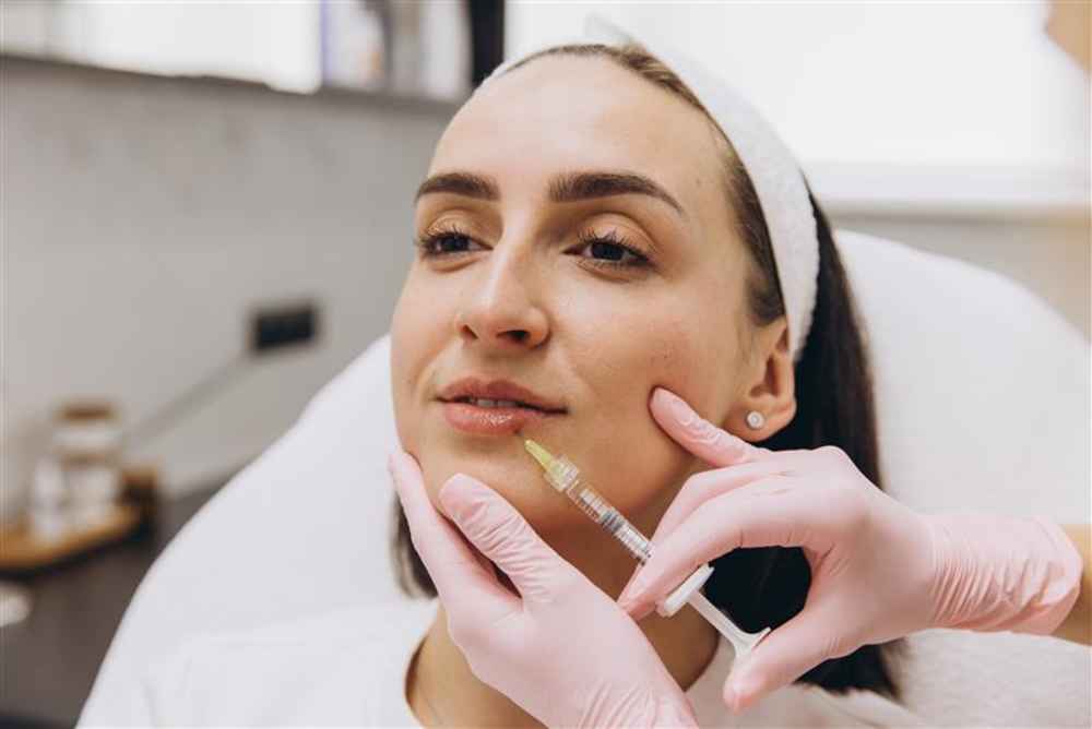 Facial plastic surgeon injecting filler into woman's face