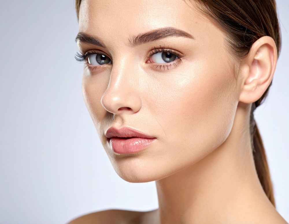 A woman's face and nose after recovering from rhinoplasty surgery
