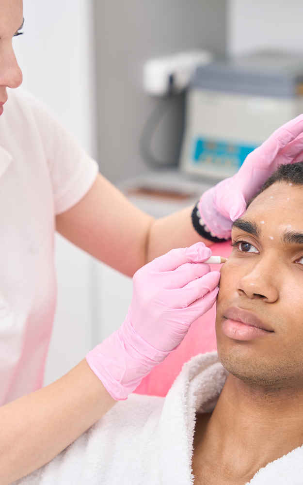 Facial plastic surgeon marking patient's face before facial feminization surgery (FFS)