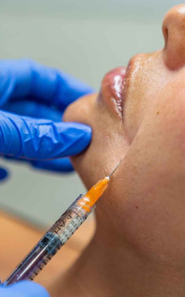 Facial plastic surgeon injecting Sculptra into patient's face