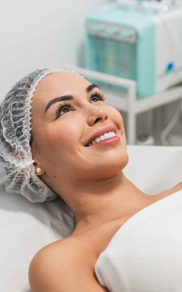 Woman lying down and smiling before being applied chemical peels on her face