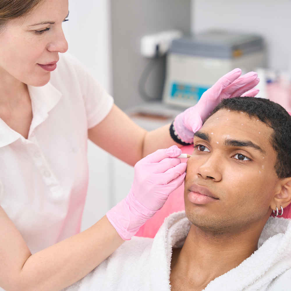Facial plastic surgeon marking patient's face before facial feminization surgery (FFS)