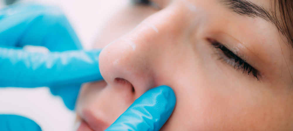 Facial plastic surgeon examining nose before rhinoplasty nose surgery