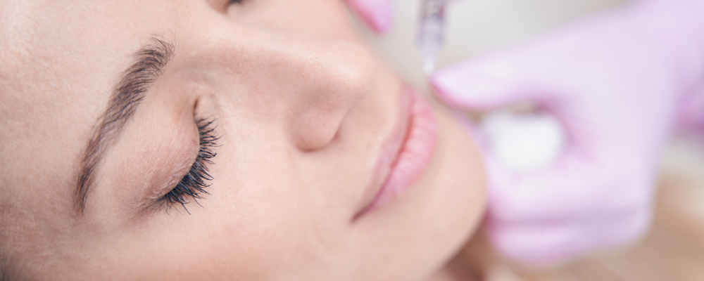 Facial plastic surgeon injecting neurotoxins into patient's face