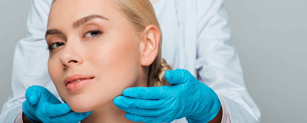 Facial plastic surgeon showing off patient's face after facelift surgery