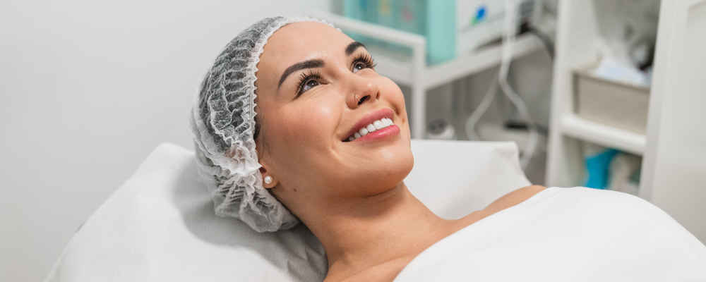 Woman lying down and smiling before being applied chemical peels on her face