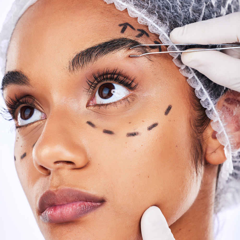 Facial plastic surgeon examining patient's face before browlift surgery