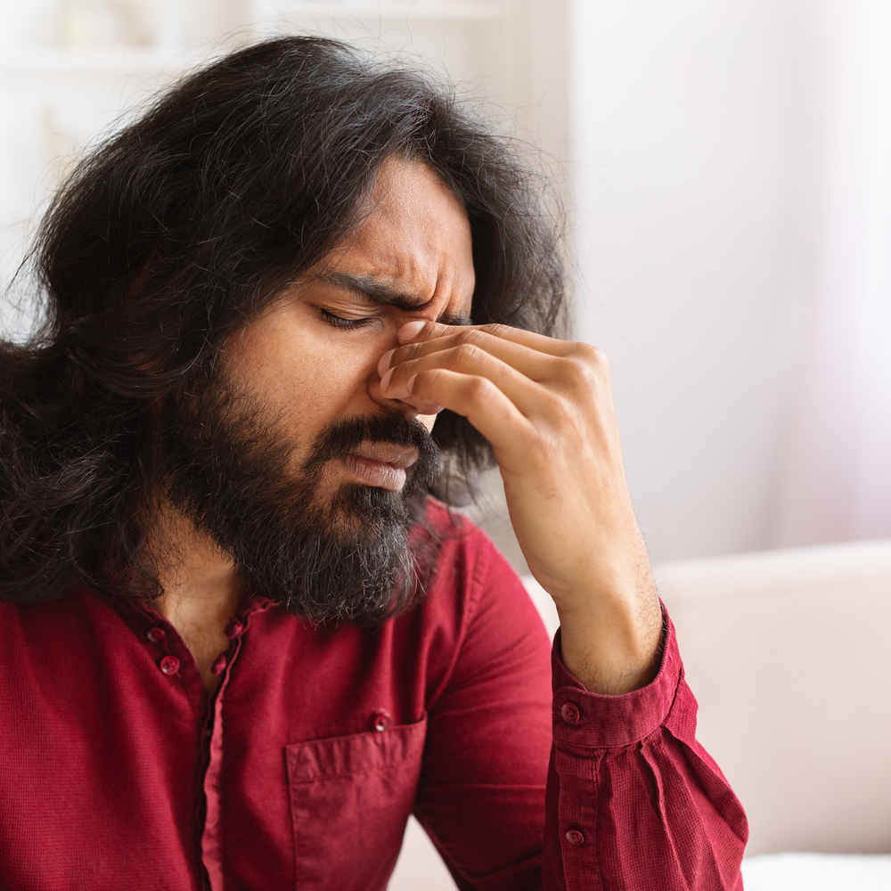 Man holding sinus area on his nose