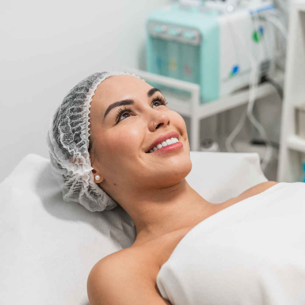 Woman lying down and smiling before being applied chemical peels on her face